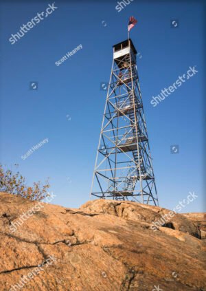 A tall mountain fire tower sitting on a rocky summit. Beacon, New York